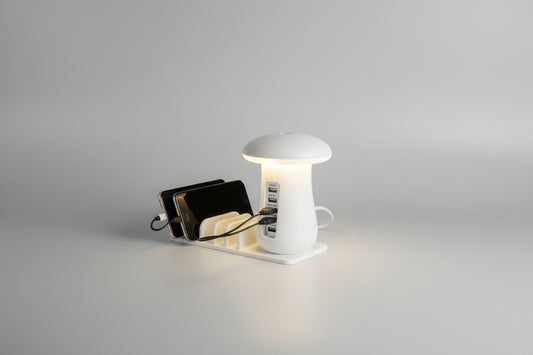 Mushroom-style LED charging strip with multiple devices plugged in on a table.